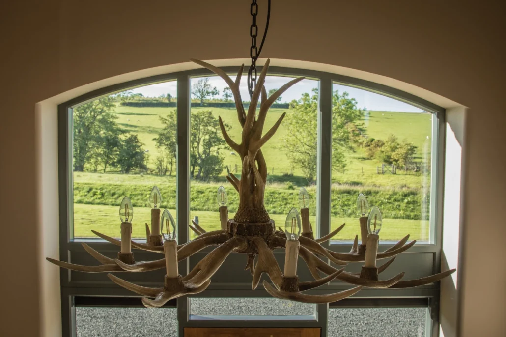 Antler chandelier in Brockram Hallway with view of fields through the window